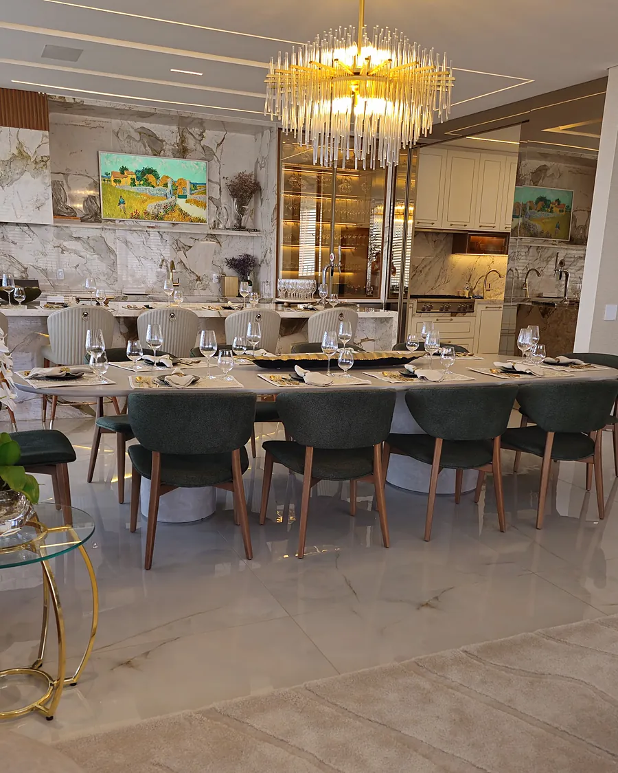 Sala de jantar com painel em pedra, lustre e marcenaria iluminada